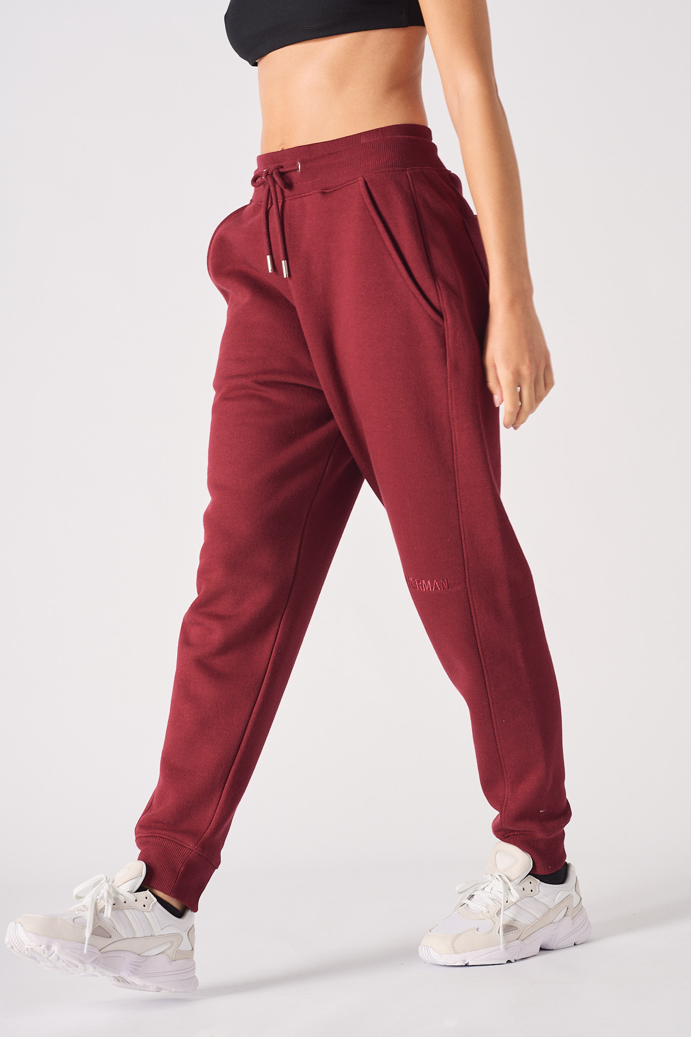 Detailed view of the side pocket on womens burgundy tapered joggers