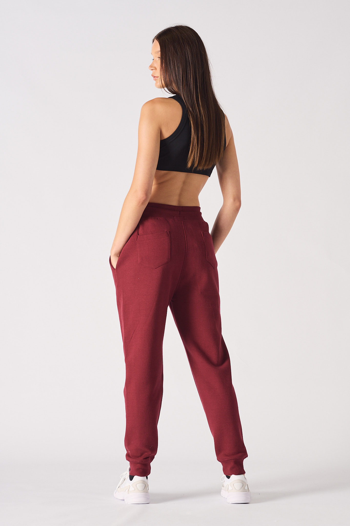 Model wearing open burgundy zip hoodie and matching tapered joggers