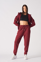 Rear view of model wearing burgundy tapered joggers tracksuit set