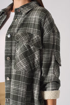Detailed view of the rolled sleeve showing the fleece lining on the women's checked overshirt.