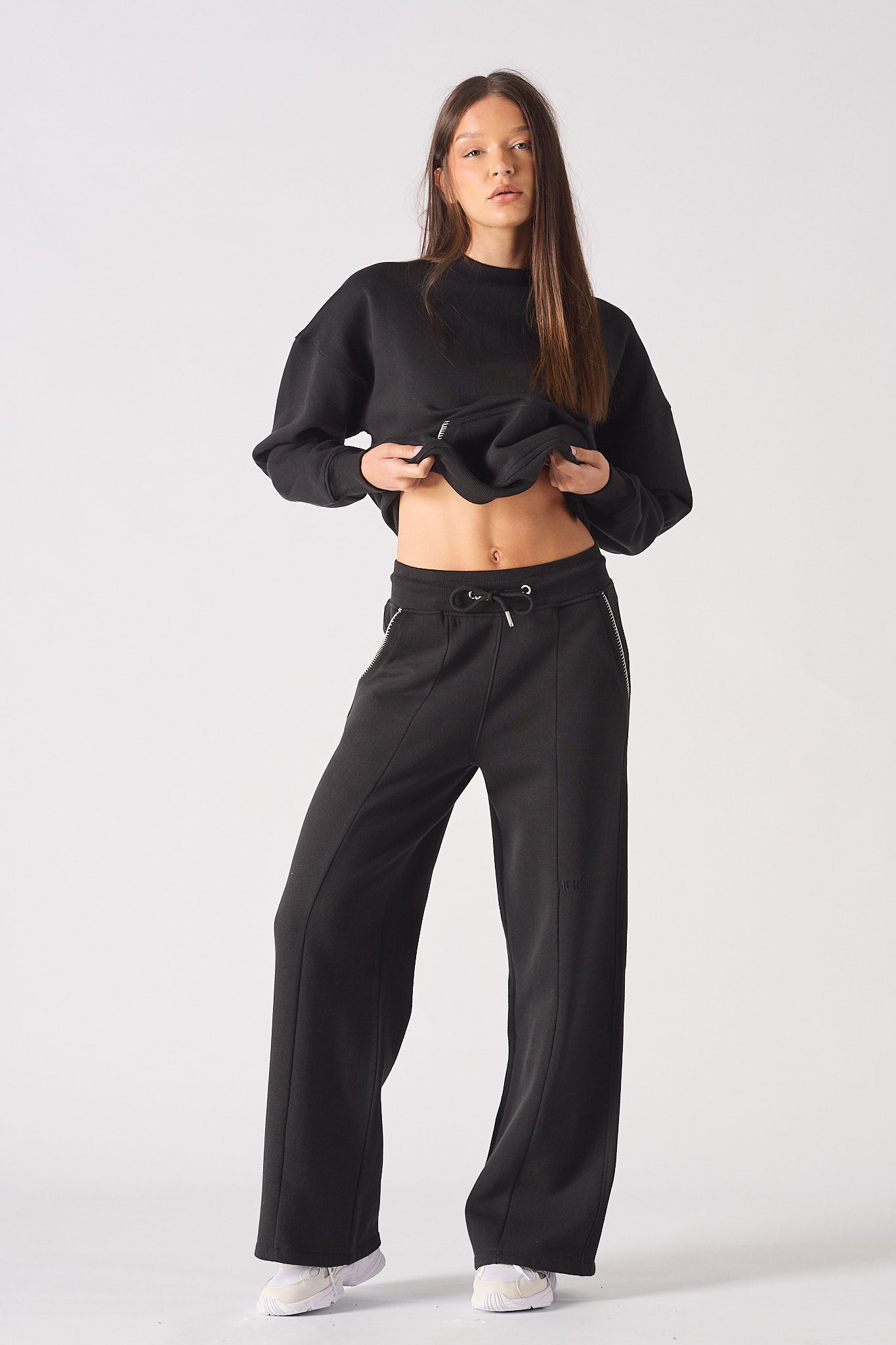 Full length view of model wearing black contrast stitch jogger with matching hoodie