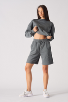 Front view of model wearing womens cool grey fleece shorts with matching sweatshirt