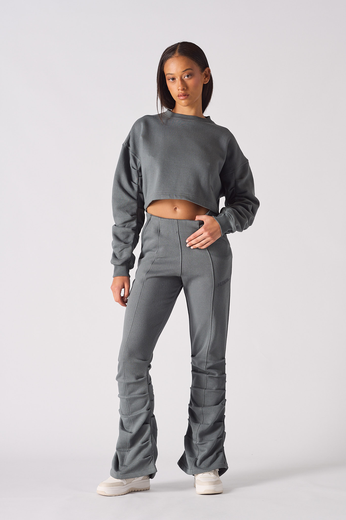 Model posing in womens grey crew neck jumper with a stylish cropped fit