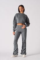 Model posing in womens grey crew neck jumper with a stylish cropped fit