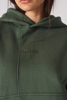 Flat lay front view of essential womens dark green hoodie