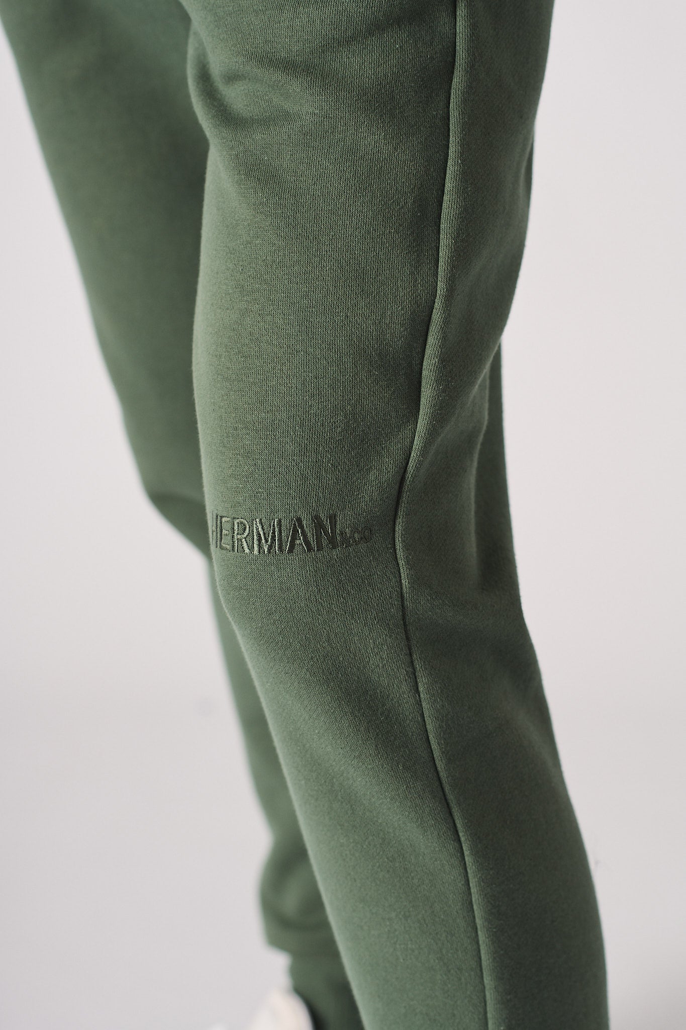 Detailed view of the side pocket on the women's dark green joggers.