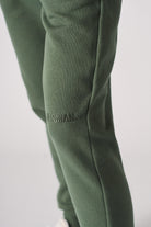 Detailed view of the side pocket on the women's dark green joggers.