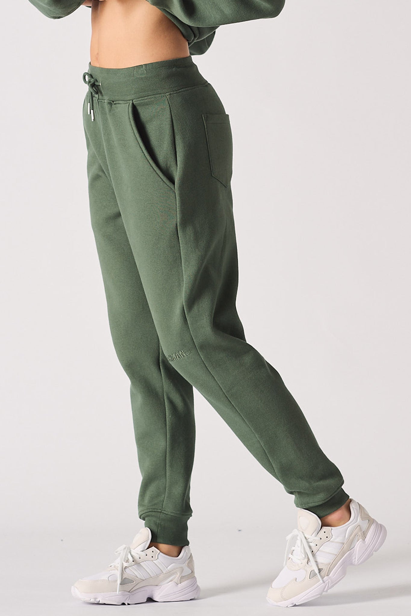 Side view of the women's dark green tapered joggers.