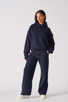 Woman wearing a dark navy hoodie women style with matching wide leg joggers