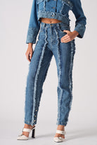 Front close-up of the women's distressed blue straight leg jeans with frayed seams.