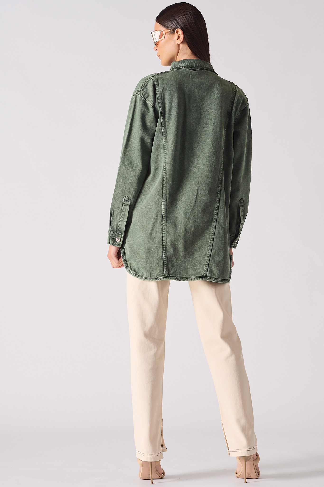 Back view of the women's green denim shirt showing its length and fit.