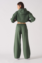 Back view of a model wearing the women's green joggers and cropped hoodie set.