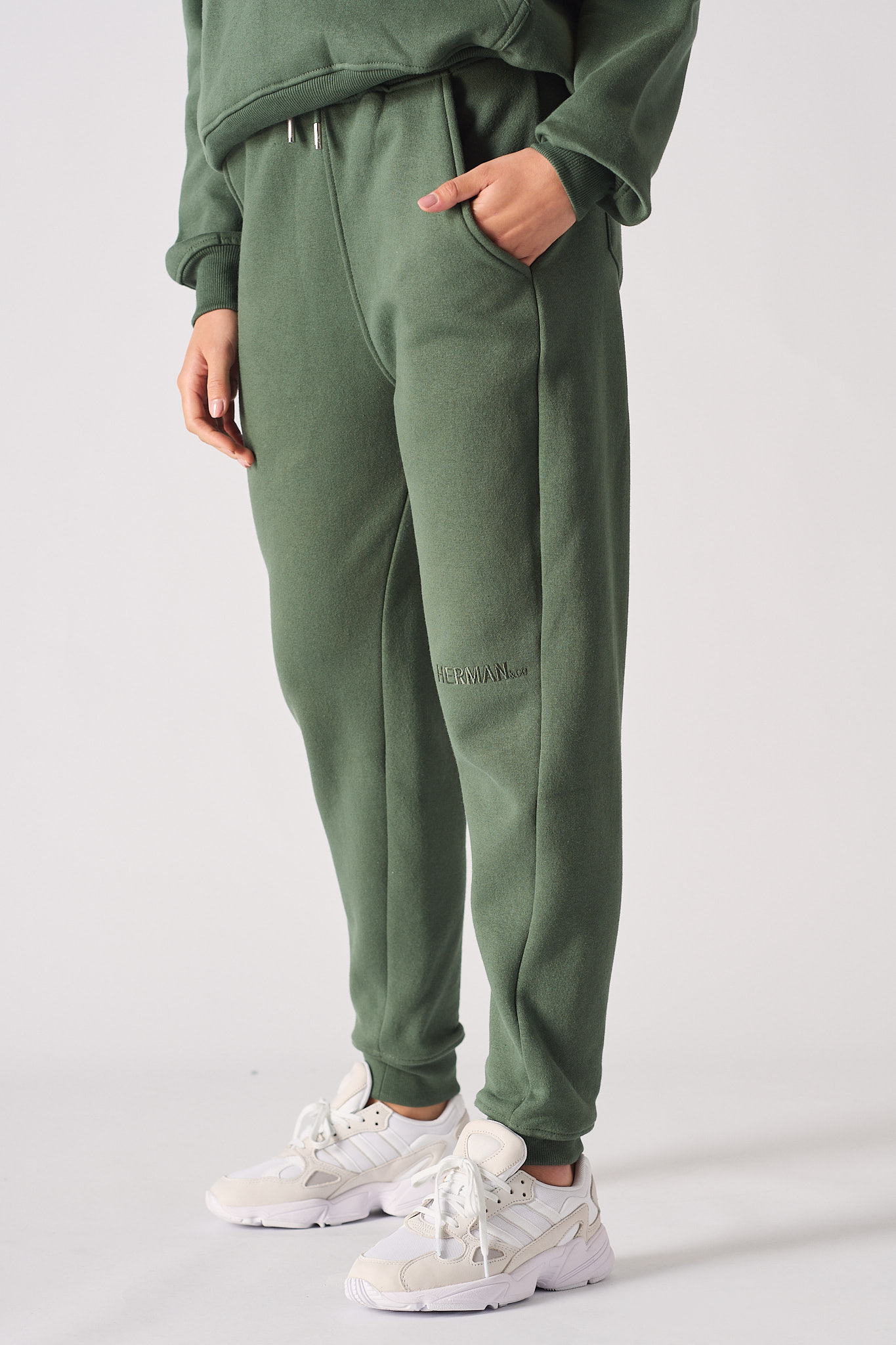 Angled side view showing the tapered fit of the women's green joggers.