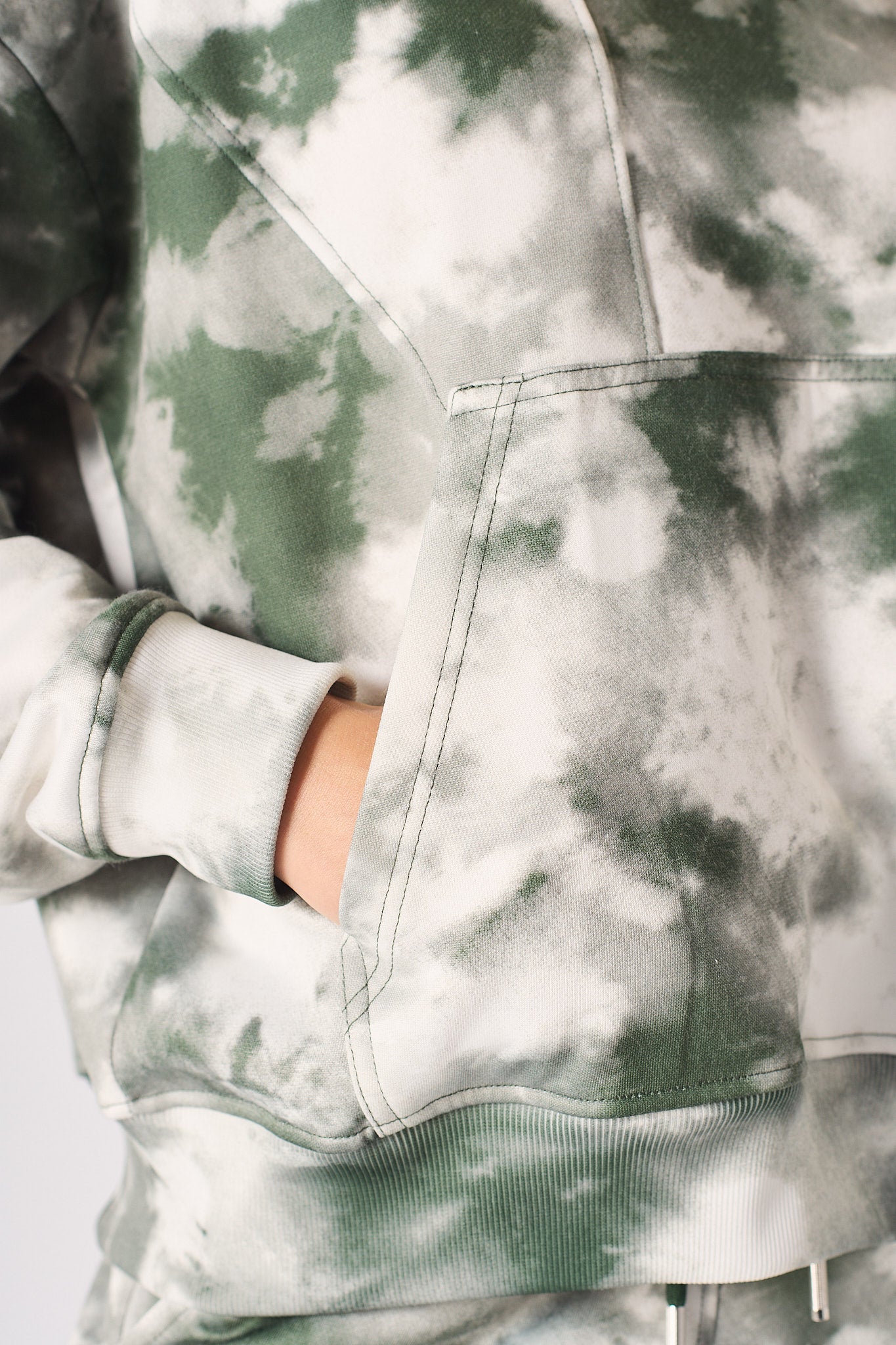 Model posing in a casual womens tie dye dark green hoodie with a relaxed fit