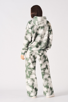 Rear full body view of womens tie dye dark green hoodie and joggers set