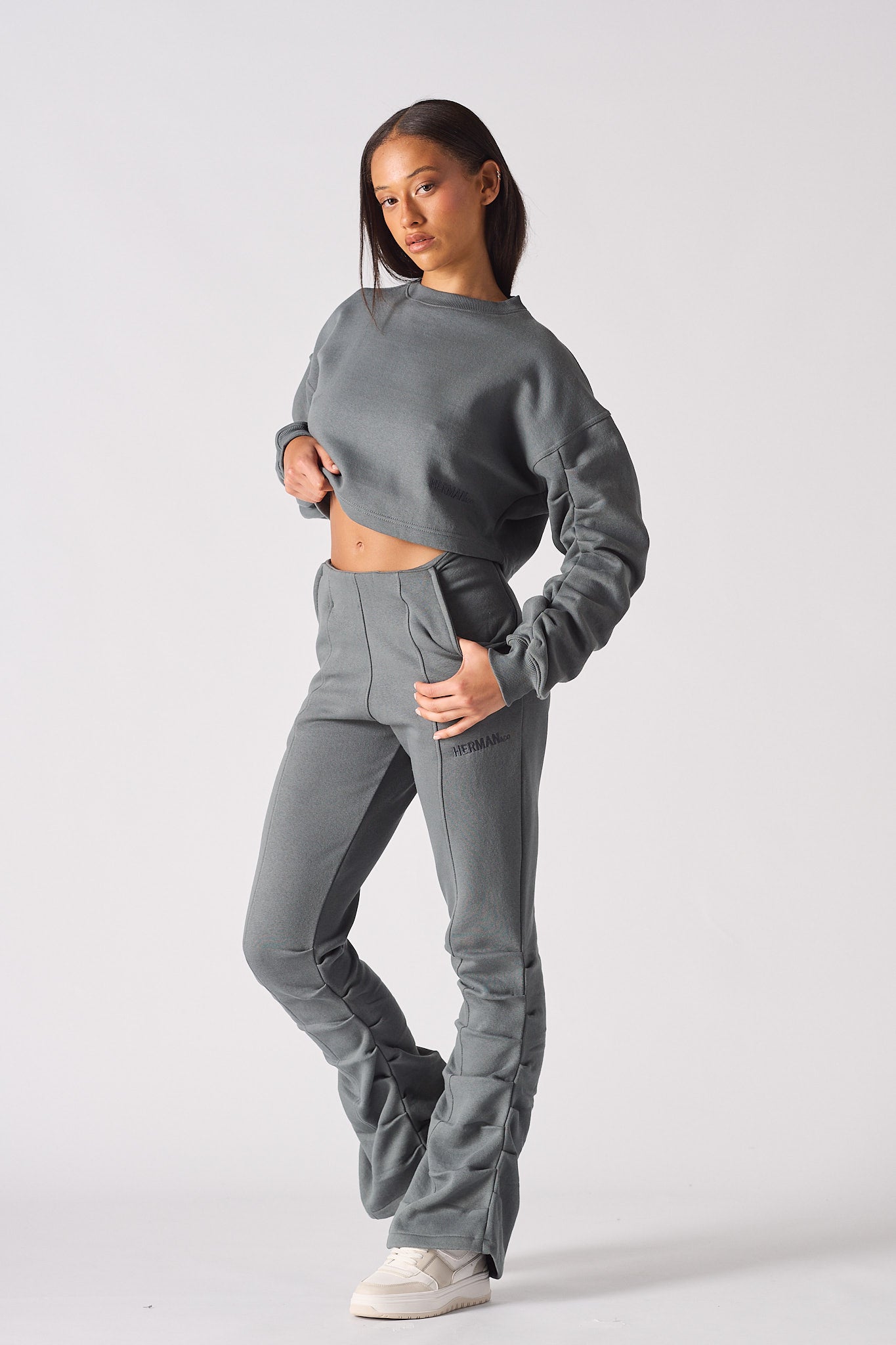 Front view of model wearing womens grey crew neck jumper with tack sleeve detail