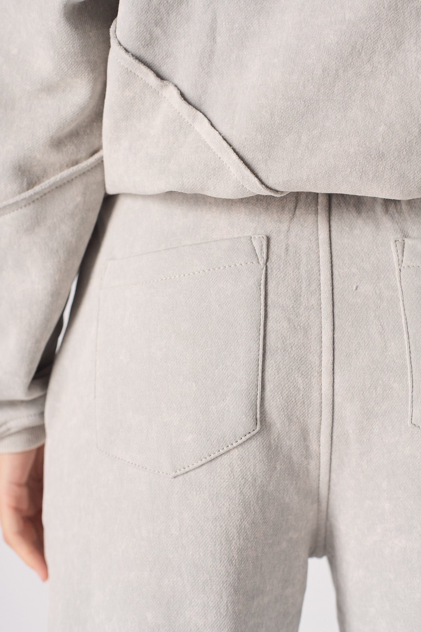 Close-up of the back pocket and seam detail on the women's grey joggers.