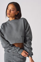 Side angle view of model in a cool grey crew neck jumper womens