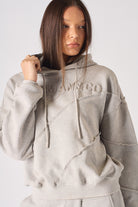 Full length side angle view of model wearing womens oversized grey hoodie and joggers