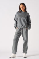 Full length side angle view of model wearing womens oversized grey sweatshirt and joggers