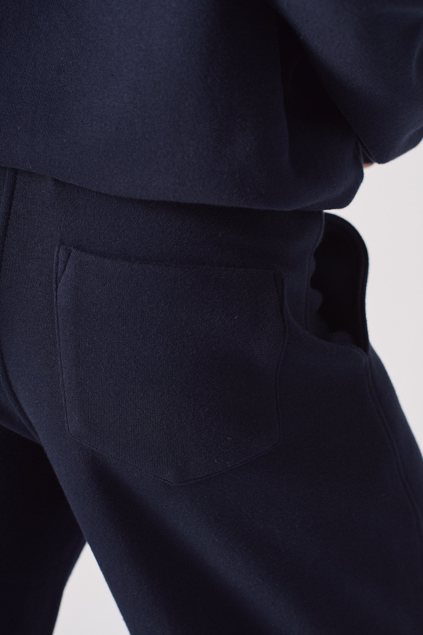 Close-up of the back pocket on the women's navy joggers.