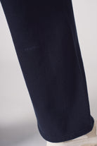 Detailed view of the embroidered logo on the leg of the women's navy joggers.