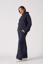 Side profile of a model wearing the women's navy wide-leg joggers.