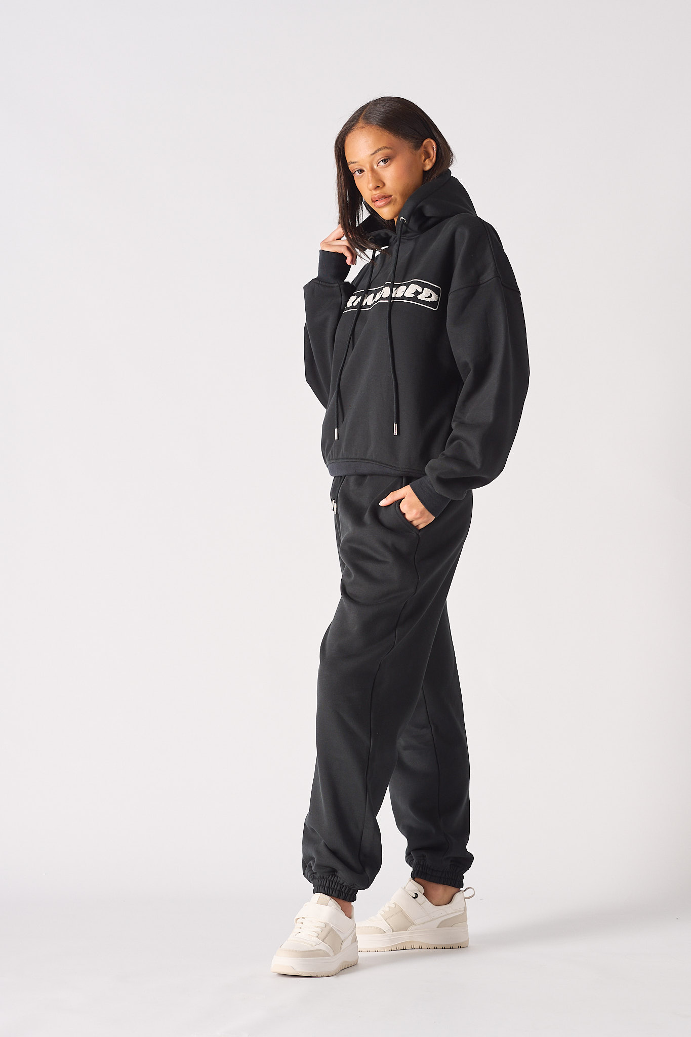 Side profile view showing the relaxed fit of womens black oversized hoodie