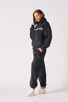 Side profile view showing the relaxed fit of womens black oversized hoodie