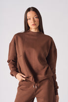 Mid shot of women wearing a comfortable brown crew neck jumper stylishly