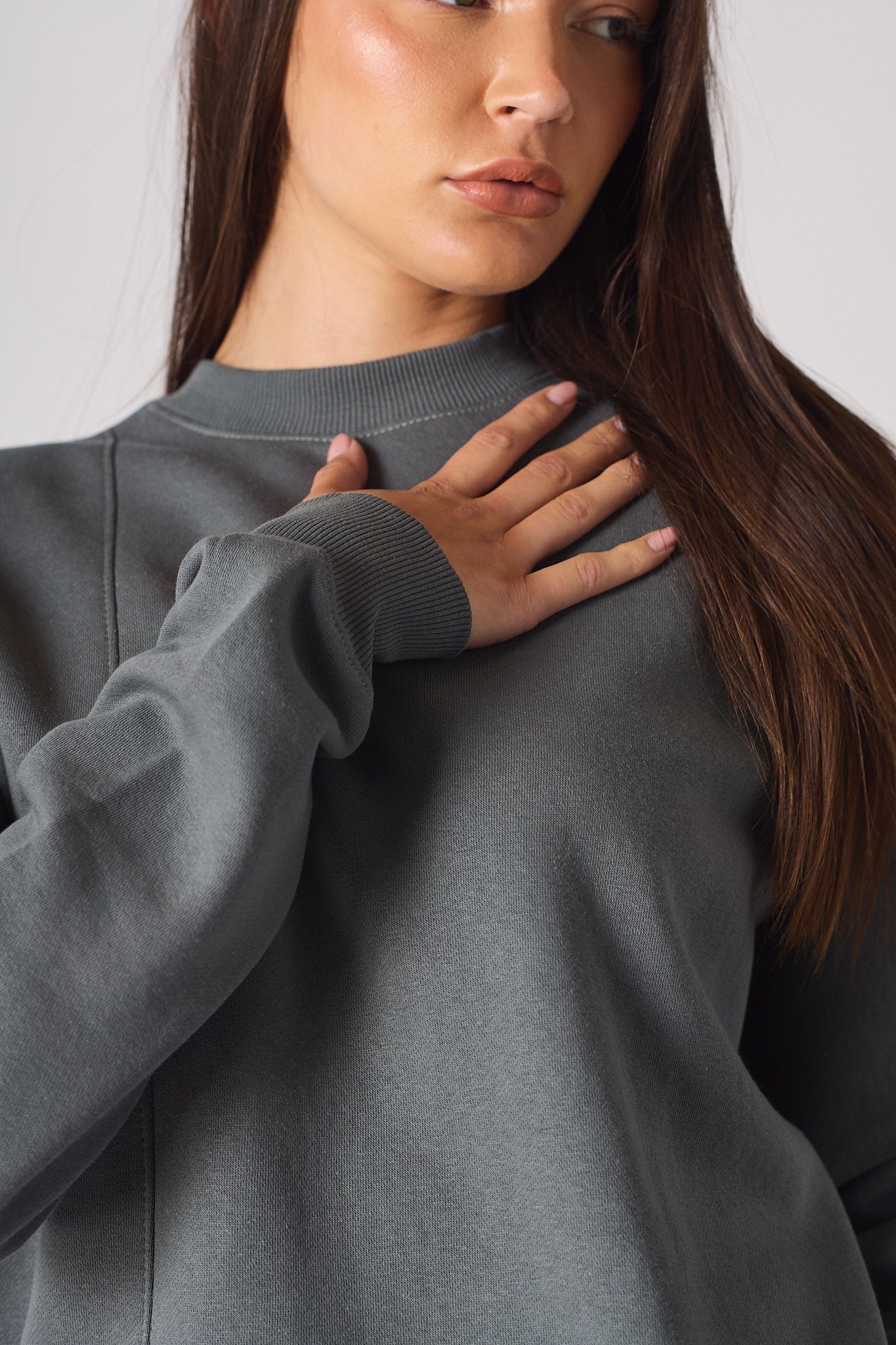 Mid shot of model wearing oversized grey crew neck jumper casual style