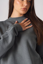 Mid shot of model wearing oversized grey crew neck jumper casual style