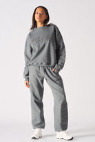 Front view of model wearing womens oversized grey sweatshirt with matching wide leg joggers