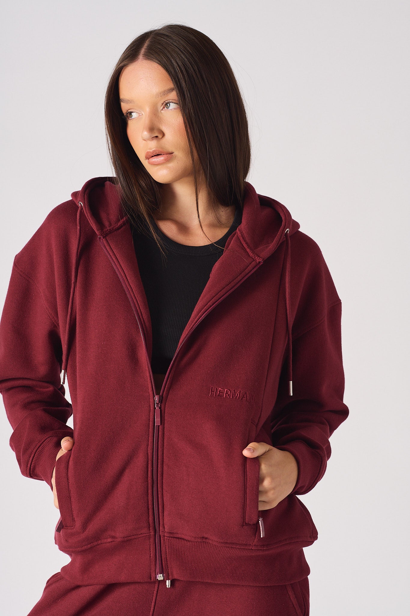 Close-up of a model wearing the women's red zip-up hoodie.