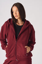 Close-up of a model wearing the women's red zip-up hoodie.