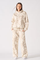 Side profile view showing the loose fit of the womens beige tie dye hoodie