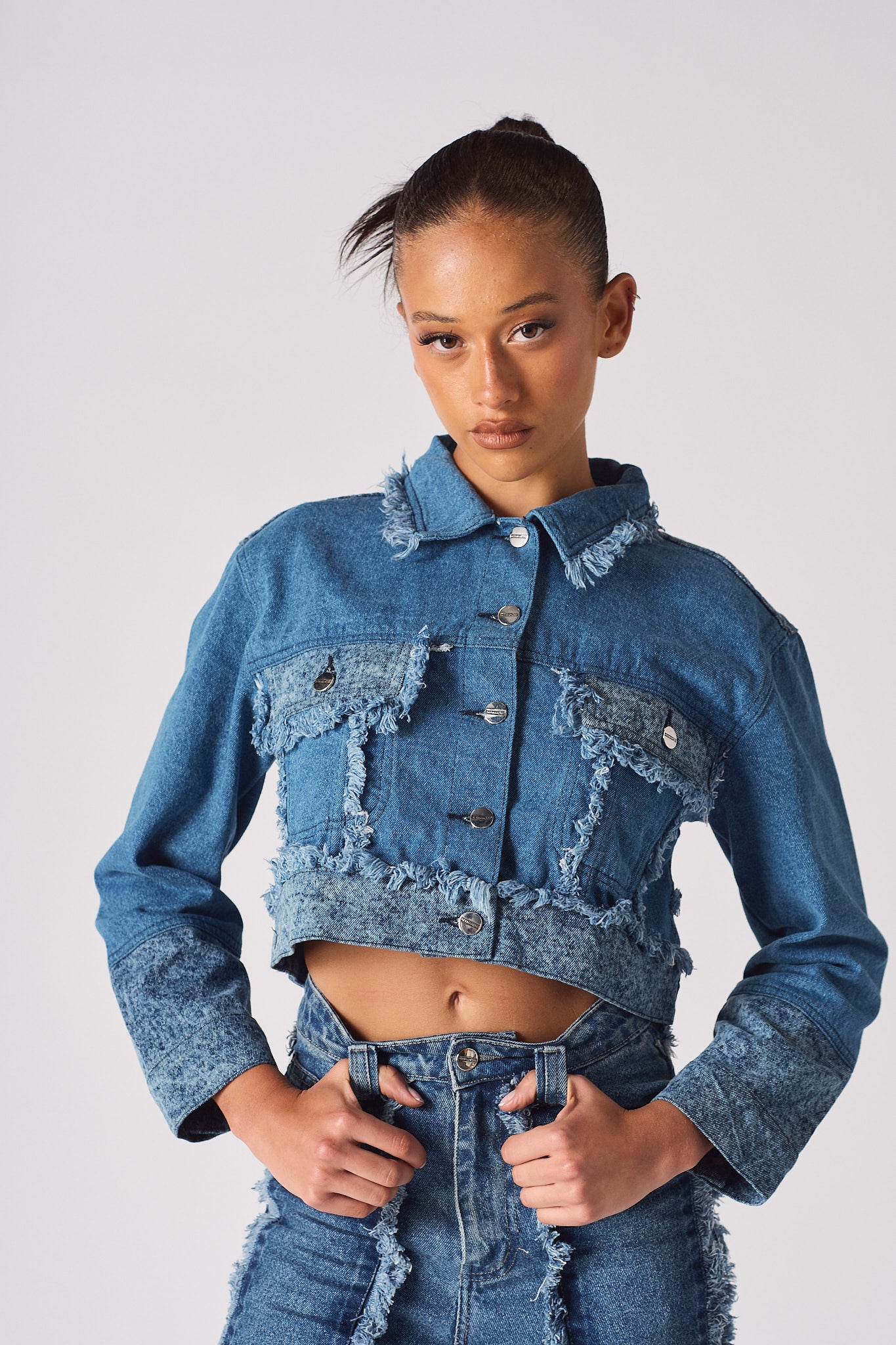 Close-up of the women's two-tone denim crop jacket showing the frayed details.