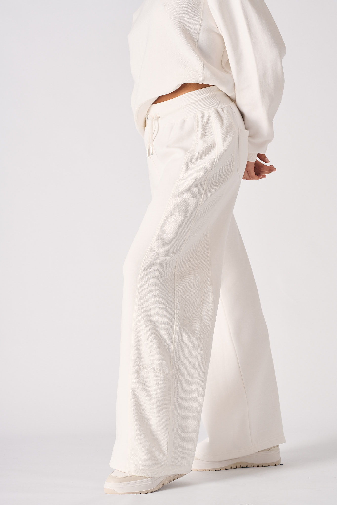 Side view of the women's white wide-leg joggers showing the relaxed fit.
