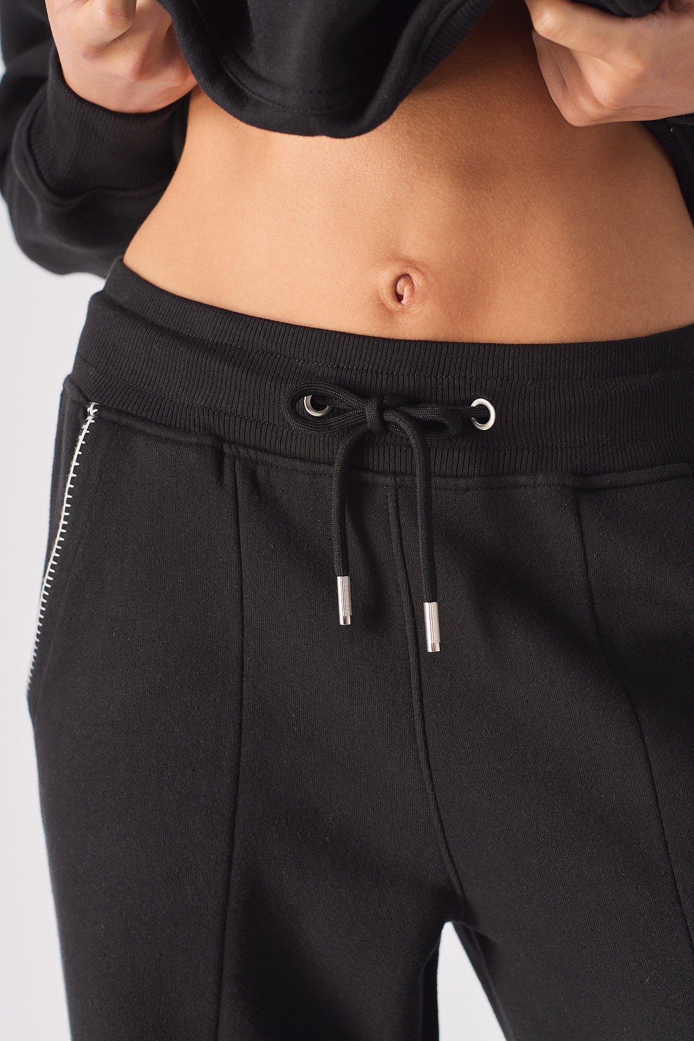 Studio shot of model posing in black wide leg joggers with contrast stitching