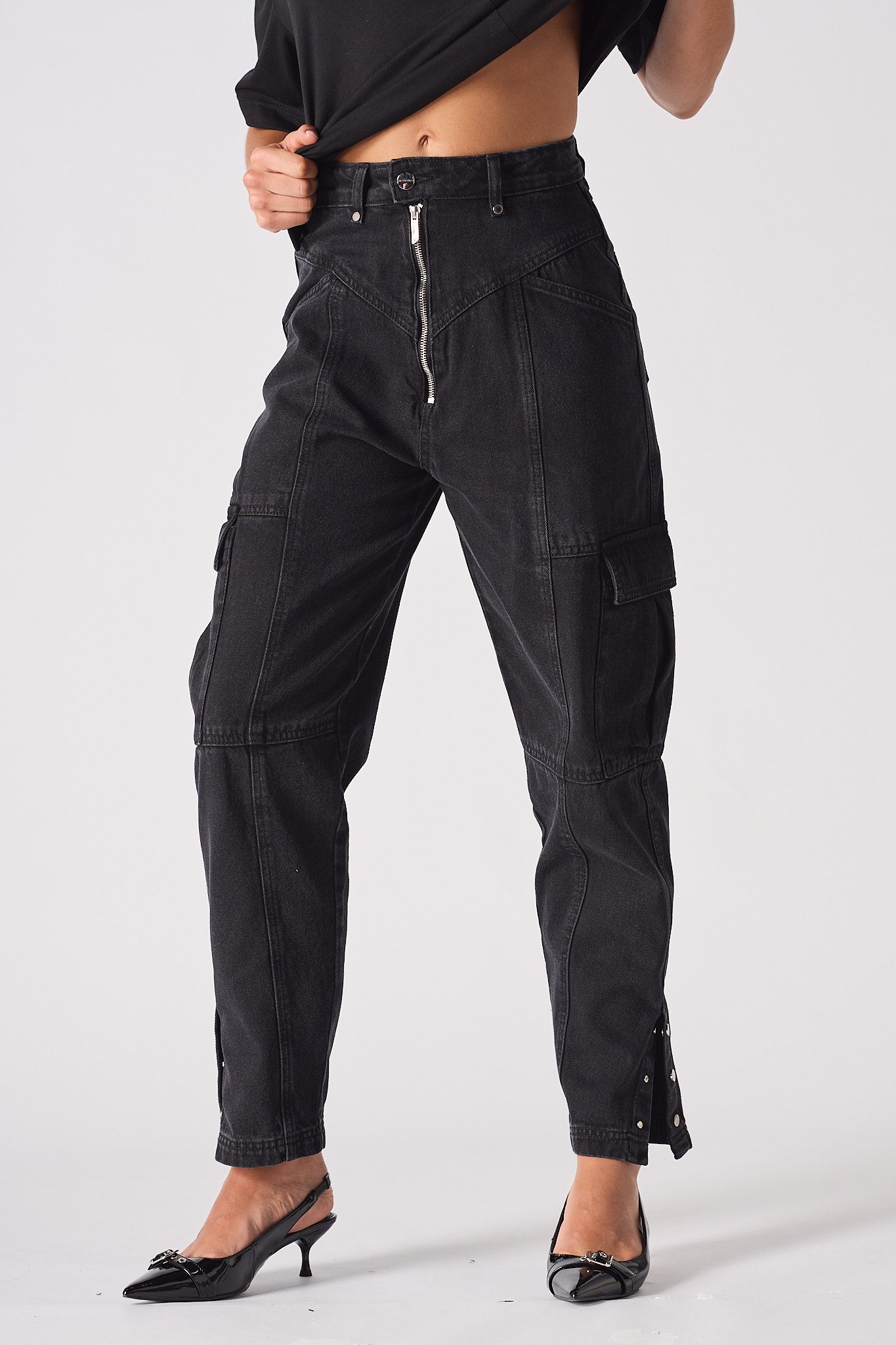 Close-up of the women's black cargo jeans showing the zip front and pocket details.