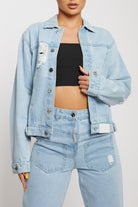 Close-up of the women's light wash distressed jacket showing the rip details.