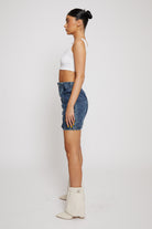 Side profile view showing the fit of the high-waisted acid wash jean skirt