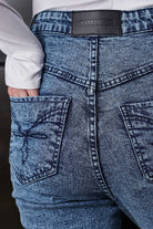 Close-up of the embroidered back pocket detail on the acid wash jeans