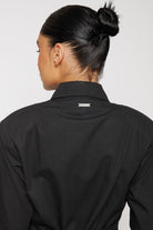 Close-up of the logo detail on the back of the asymmetric shirt dress collar.