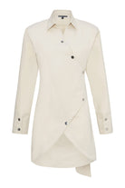 Front view of the beige cotton asymmetric shirt dress laid flat.