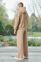 Rear view of men wearing a relaxed fit beige hoodie showing the back design