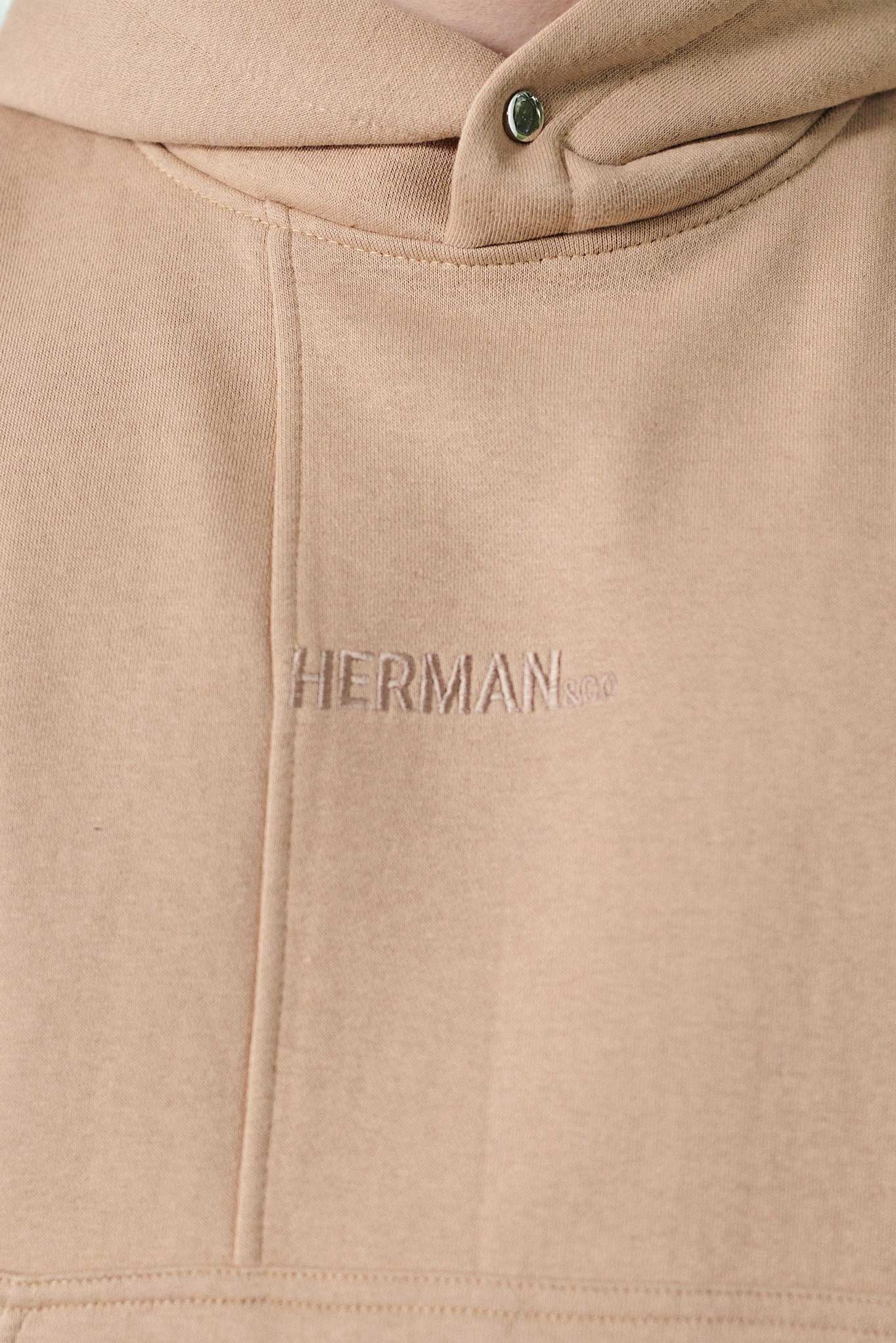 Detailed view of the kangaroo pocket on mens beige pullover hoodie