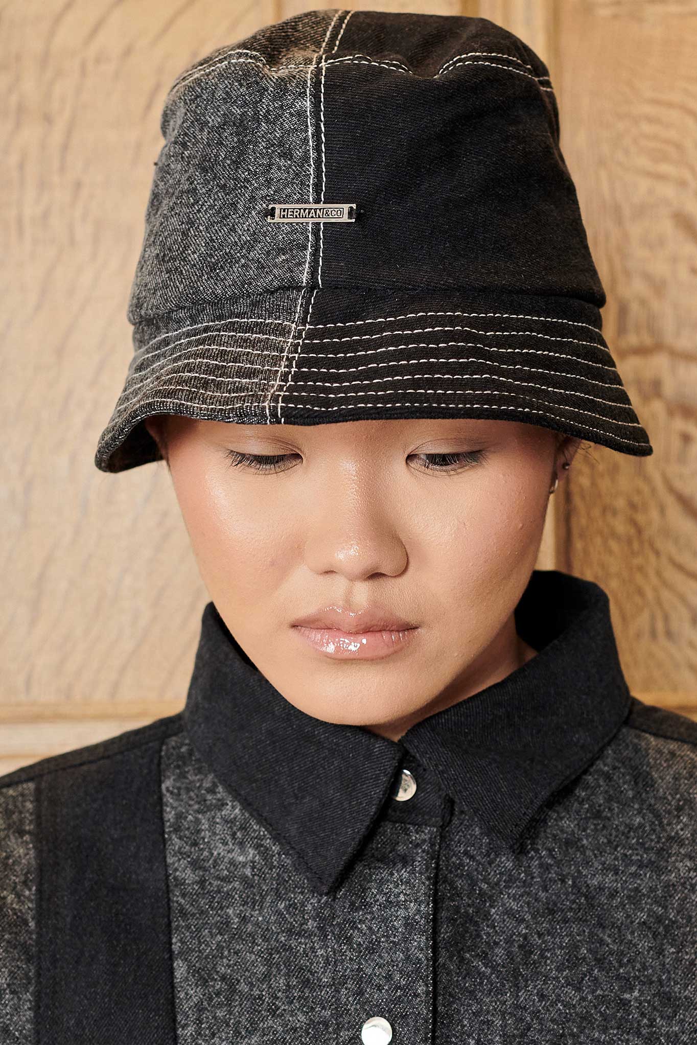 A model looking down while wearing the black acid wash bucket hat