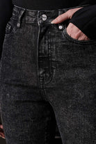 A close-up view of the black acid wash fabric and texture on the jeans