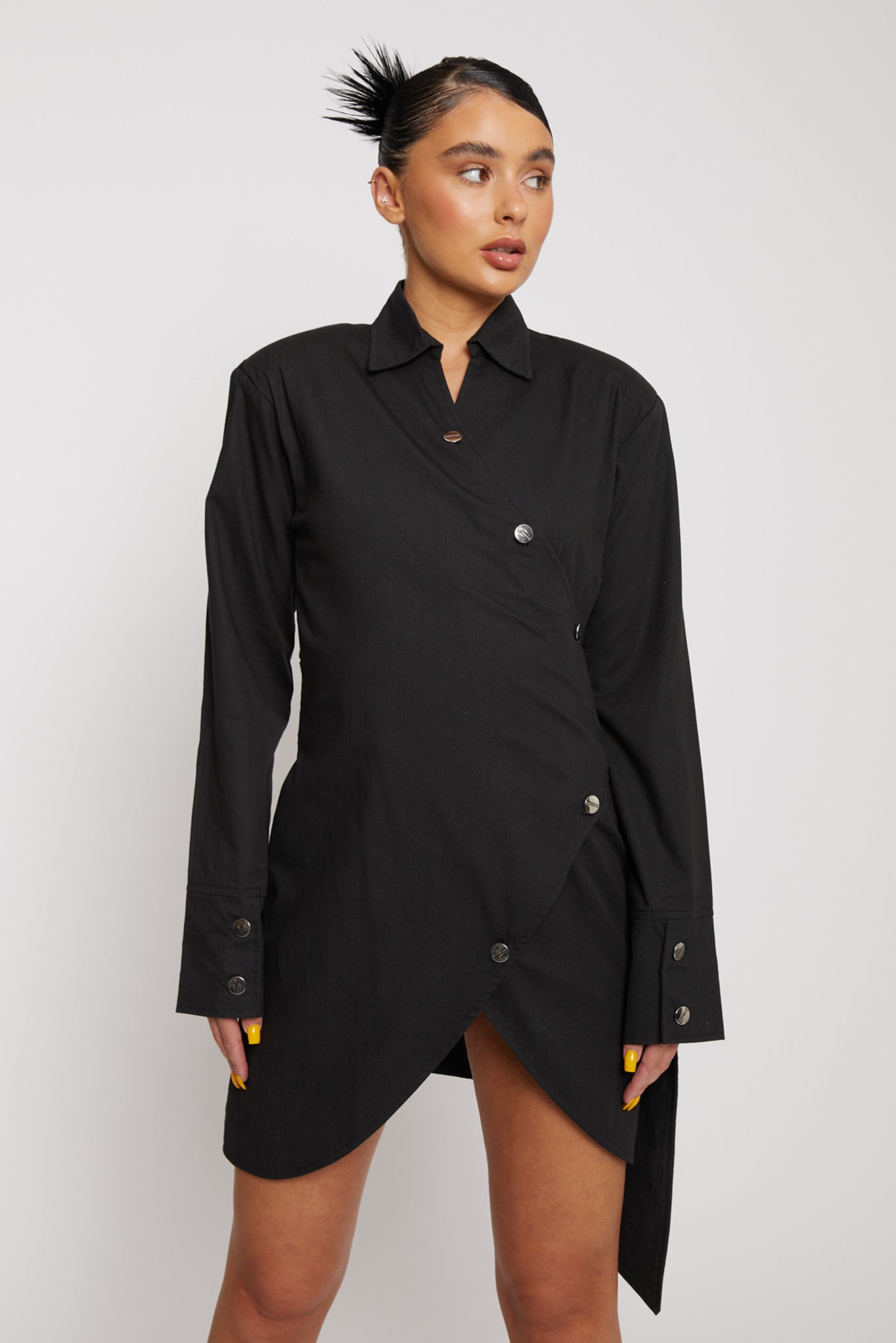 Close-up of the black asymmetric shirt dress showing the collar and button detail.